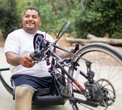 An imagine showing a man using a handbike in the park