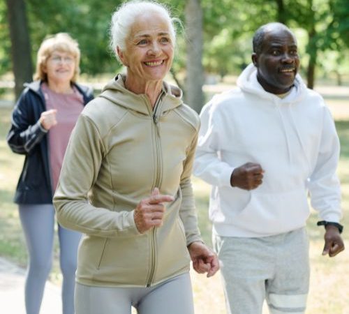 An image showing a group of older people walking in the park together