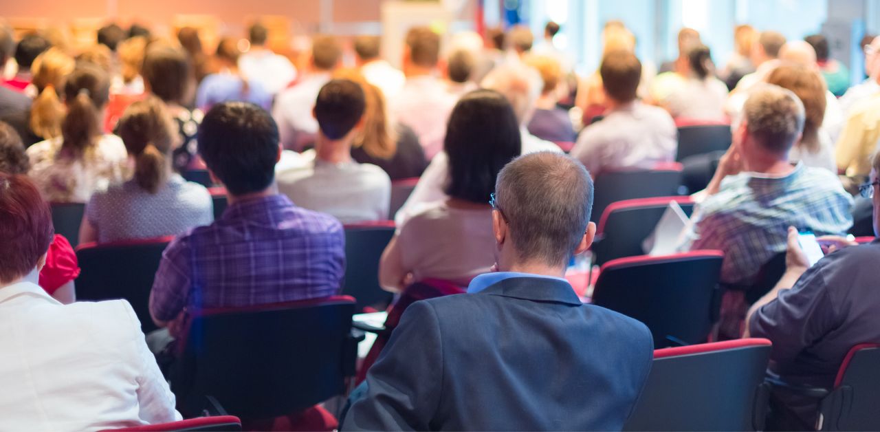 An image showing a session at a conference full of people in the audience